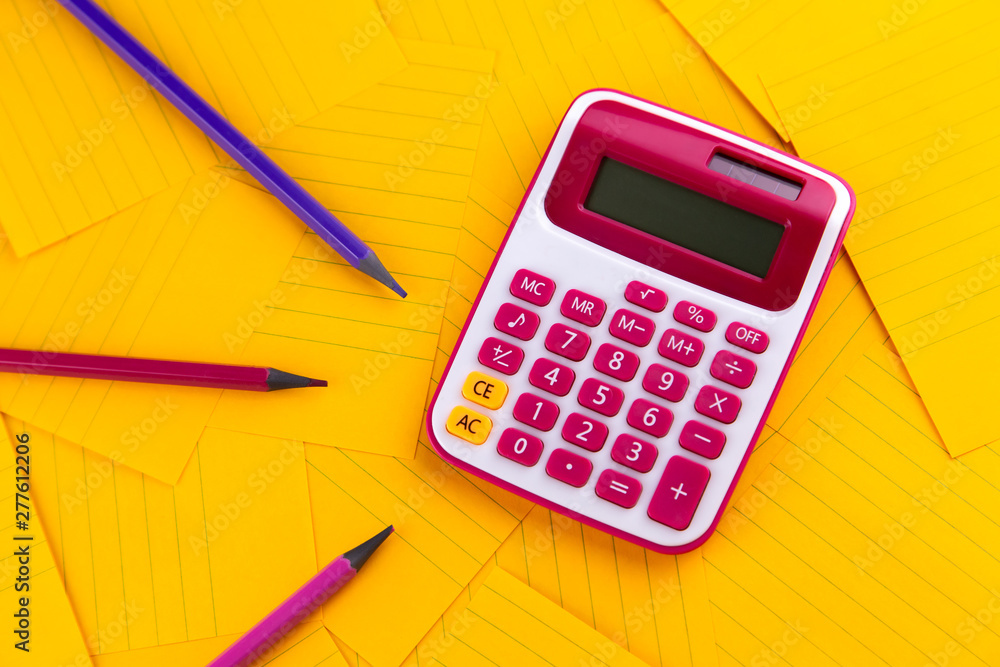 The concept of analysis, analytics, calculations. The calculator lies on orange sheets of paper with pencil The concept of analysis, analytics, calculations. The calculator lies on orange sheets of paper with pencil