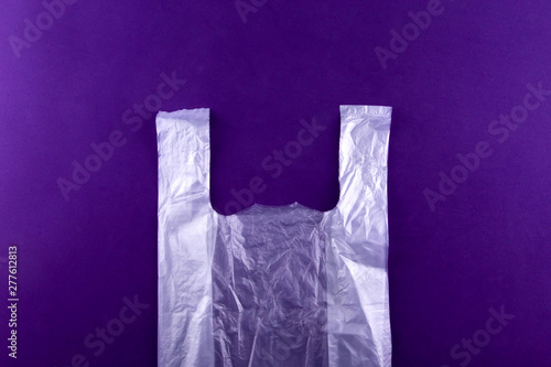 White torn plastic shopping, grocery bag on purple background. Pollution concept
