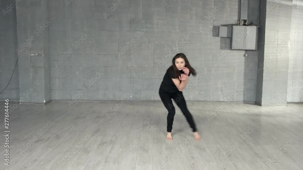 Slim girl dancing modern dance. Modern style dancer working out in studio. Professional dance studio. Slim girl dancing modern dance. Modern style dancer working out in studio. Professional dance studio.