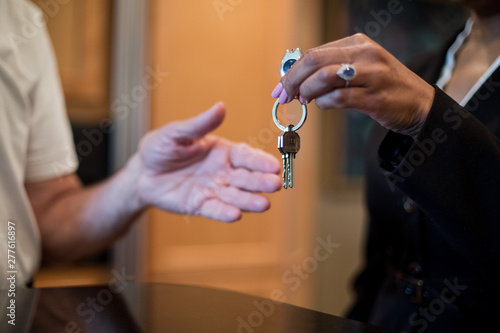 A female realtor hands over the keys to a new home to her client, an elderly man. photo