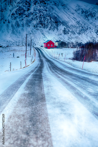 Lonely Red Rorbu House in Mountain Village at Lofoten Islands in Winter Time.