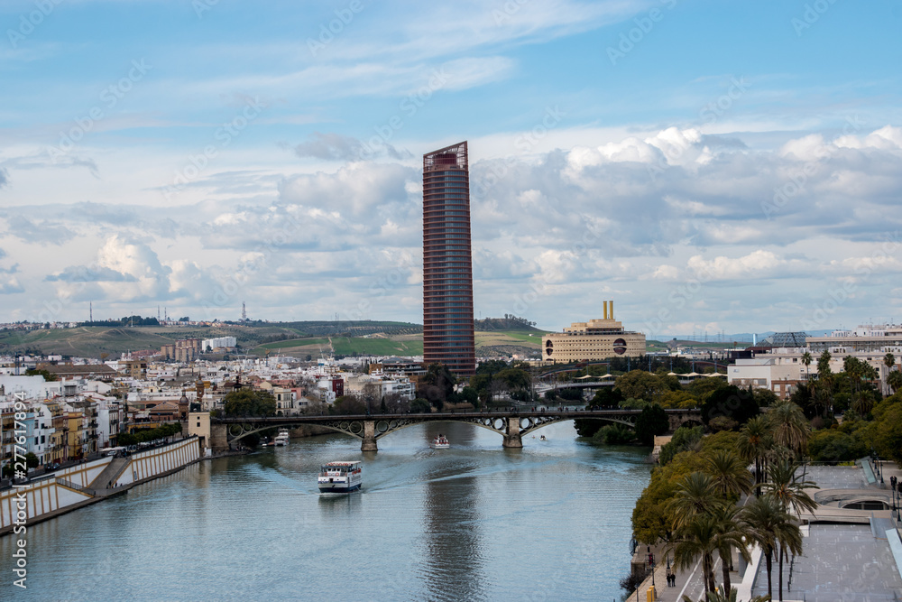 The cityscape of Seville, Spain with a ship on the Guadalaquivir and the Torre Sevilla in the backgound taken from the Torre del Oro 