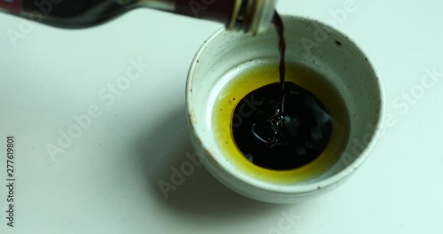 Putting olive oil and balsamic vinegar in small bowl