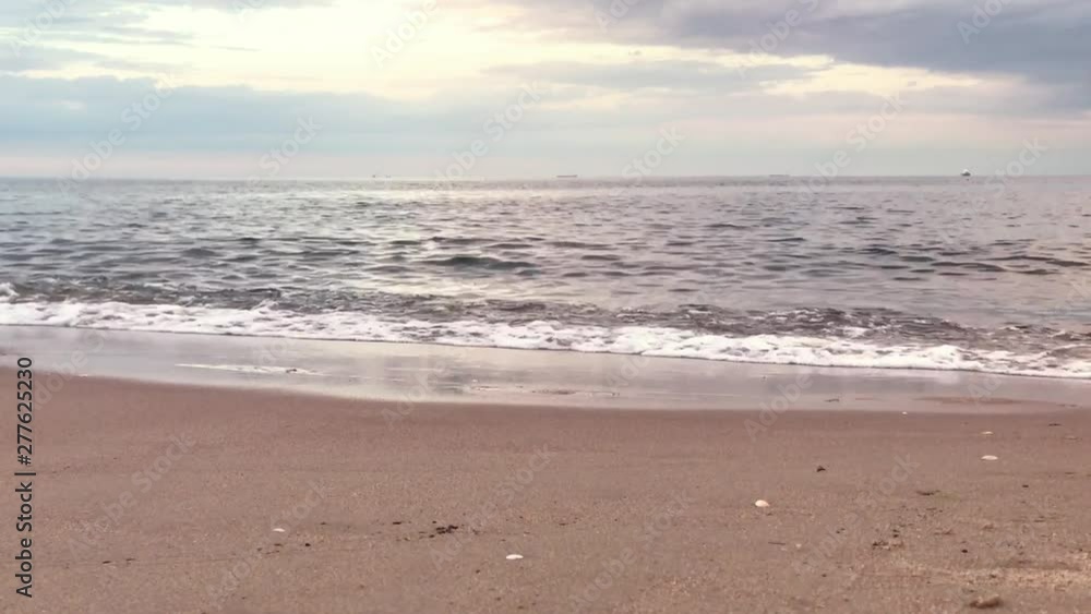 View from below of the sea. The waves end at the beach shore and nice cloudy sky on sunset View from below of the sea. The waves end at the beach shore and nice cloudy sky on sunset