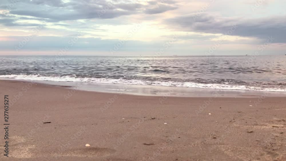 View from below of the sea. The waves end at the beach shore and nice cloudy sky on sunset View from below of the sea. The waves end at the beach shore and nice cloudy sky on sunset
