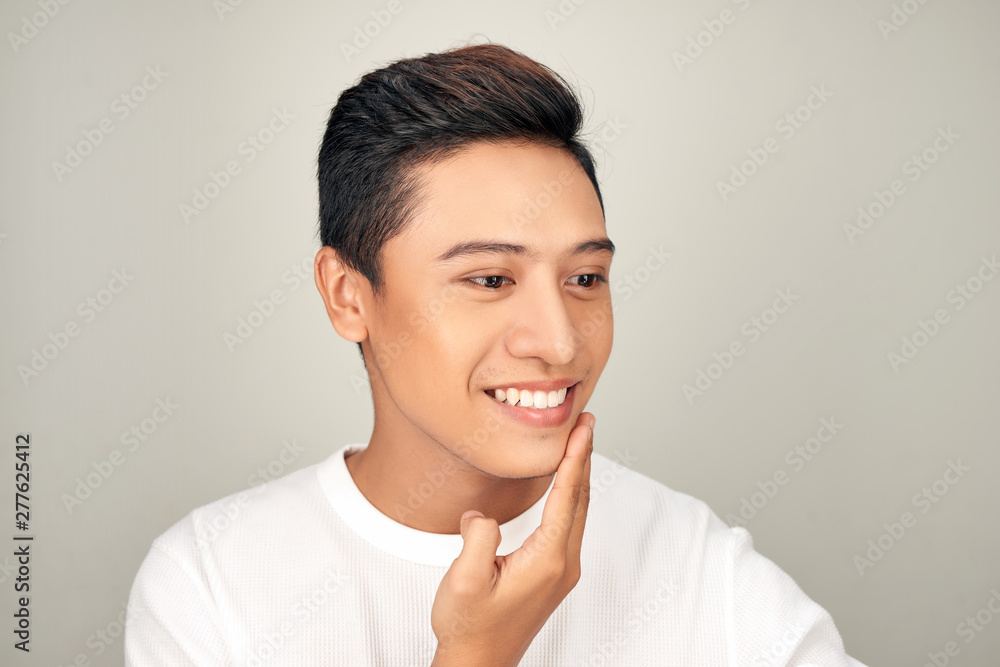 Portrait of shirtless young handsome Asian man checking his face for skin care and beauty concepts on white background Portrait of shirtless young handsome Asian man checking his face for skin care and beauty concepts on white background