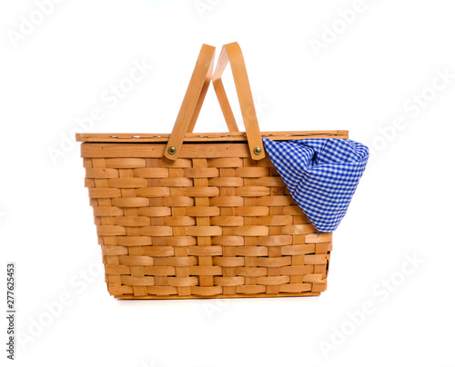 A brown wicker picnic basket on a white background with gingham cloth