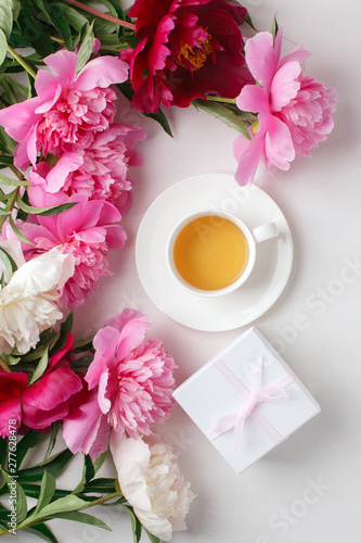 Breakfast for Valentines day with cup of tea, giftbox, flowers on white table from above in flat lay style, seasonal springtime holiday background, blogger lifestyle