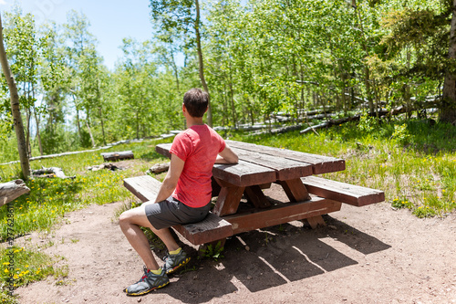 Santa Fe National Forest park Sangre de Cristo mountains with man sitting at picnic table green aspen trees in spring photo