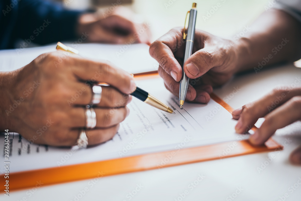 Group of middle age Asian business people and lawyers discussing and sign a contract. Group of middle age Asian business people and lawyers discussing and sign a contract.
