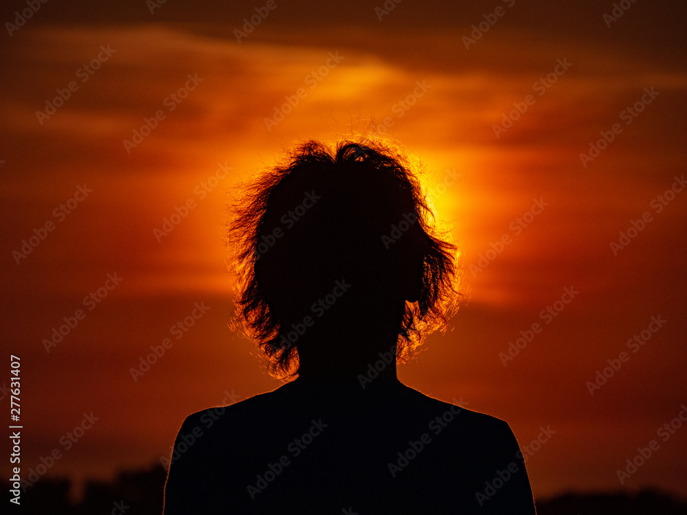 girl looking at the sunset in nature