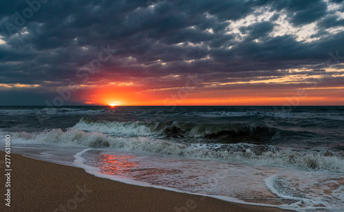 Beach with waves at colorful sunset
