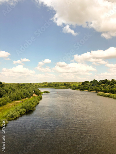 View of the river and the blue sky with clouds from the railway bridge.