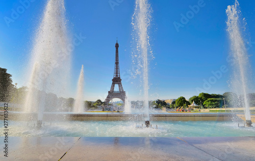 water jets in trocadero fountain on blue sky with silhouette of eiffel tower