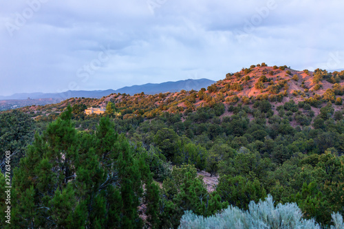 Sunset in Santa Fe, New Mexico mountains in Tesuque community neighborhood with houses, green plants and blue sky photo