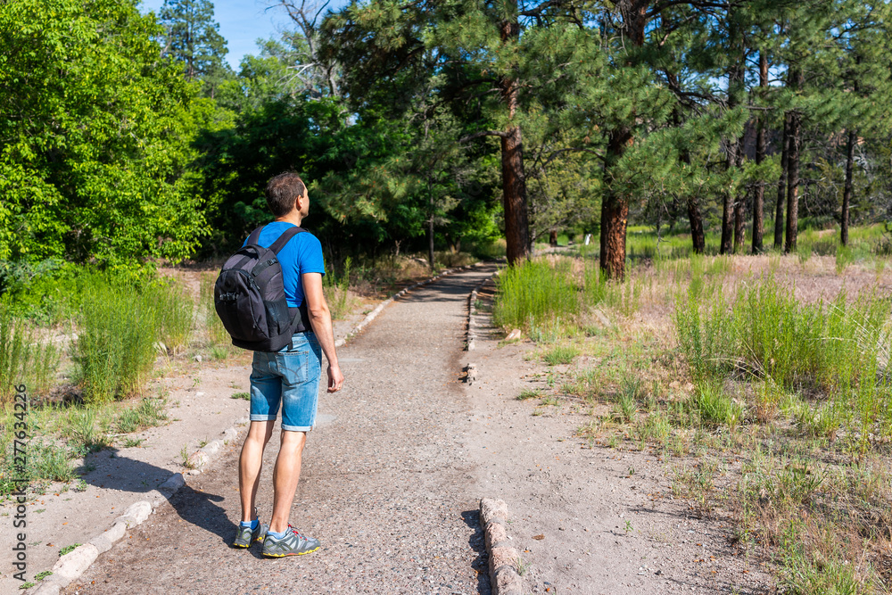Man hiking walking on Main Loop trail path in Bandelier National Monument in New Mexico during summer in Los Alamos Man hiking walking on Main Loop trail path in Bandelier National Monument in New Mexico during summer in Los Alamos