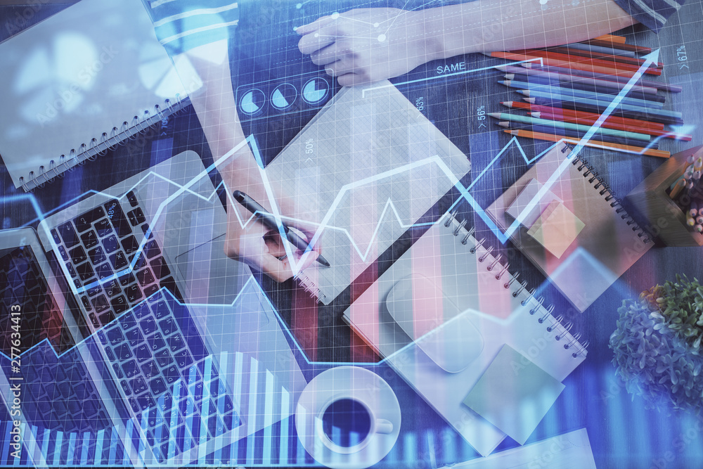 Financial forex graph drawn over hands taking notes background. Concept of research. Double exposure Financial forex graph drawn over hands taking notes background. Concept of research. Double exposure