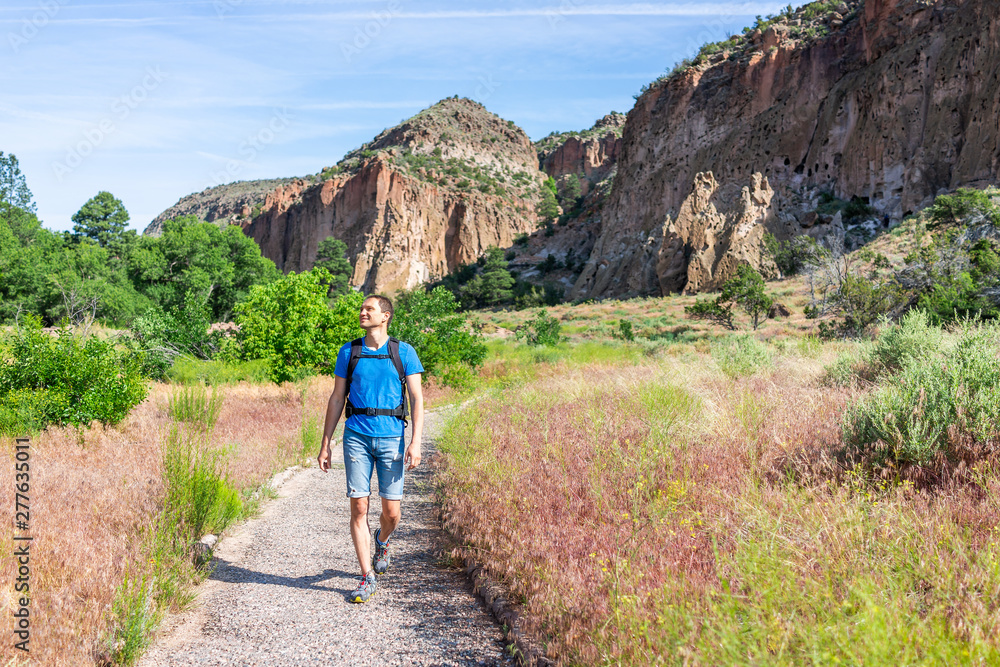 Obraz premium Main Loop path trail with man walking in Bandelier National Monument in New Mexico in Los Alamos with canyon cliffs