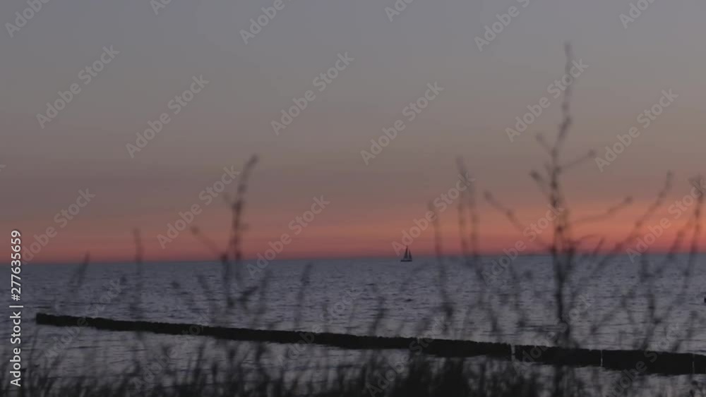 a sailboat sailing at the horizon line, at the baltic sea, while an amazing sunset (blue Hour) a sailboat sailing at the horizon line, at the baltic sea, while an amazing sunset (blue Hour)