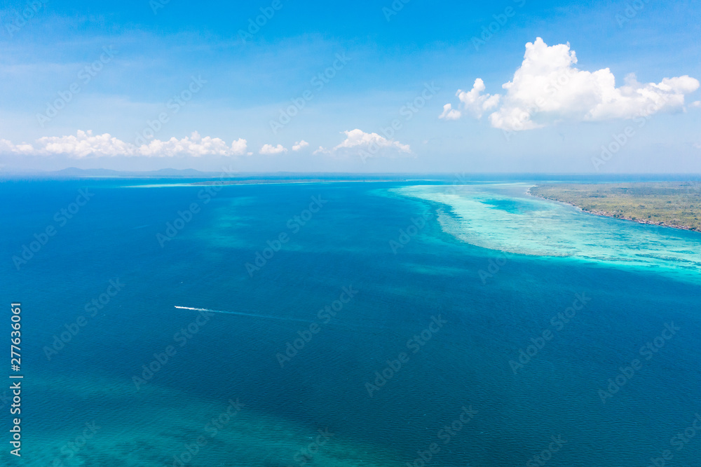 Large islands located on the atolls, a top view. Island with forest.