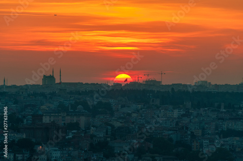 Vivid red orange sky and sun setting Istanbul aerial view