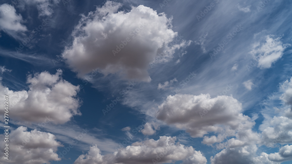 white clouds float across the blue sky white clouds float across the blue sky