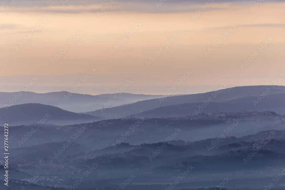 A view of Perugia city (Umbria, Italy) in the middle of hills and mist at dusk