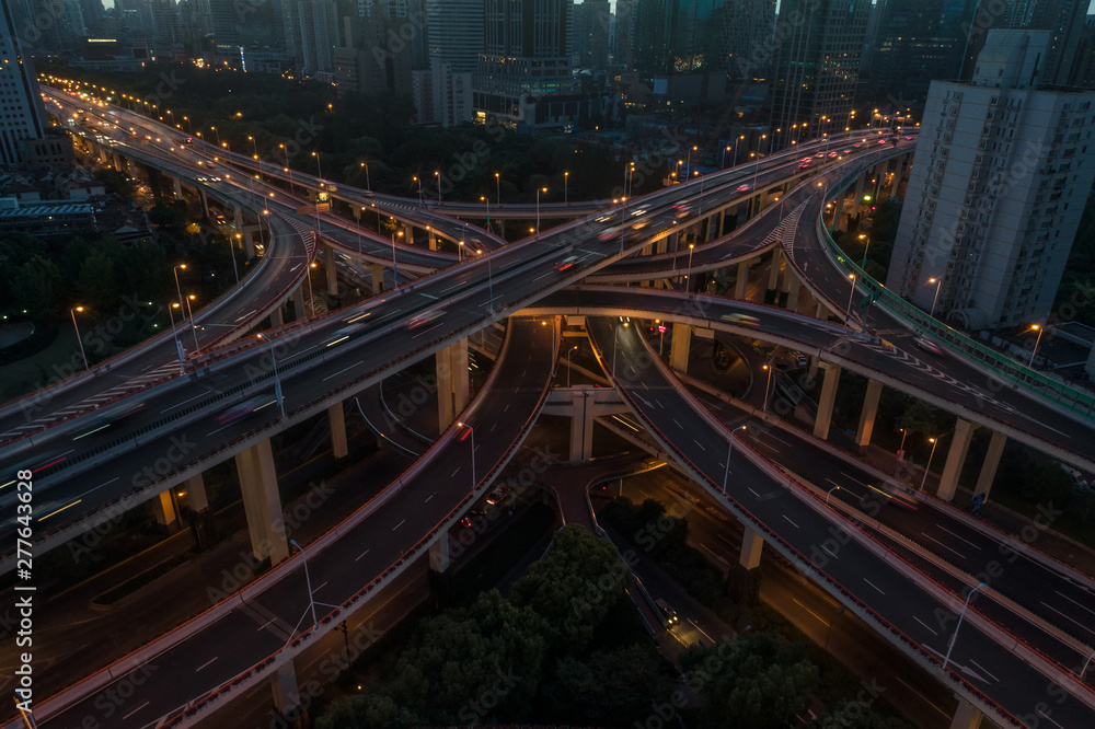 aerial view of buildings and highway interchange at dawn in Shanghai city