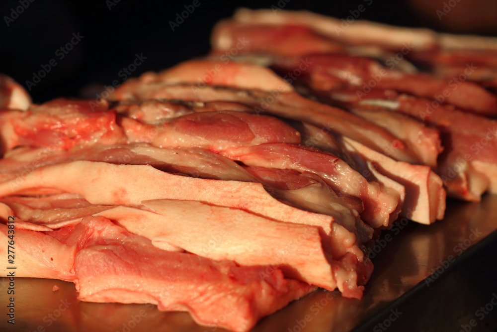 Cutting streaky pork in fresh market,close up Pork belly.