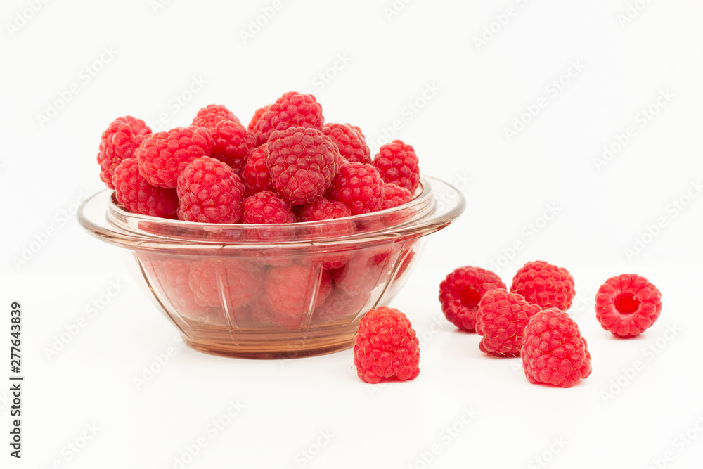 Fresh ripe raspberries on a white background in a glass jar and scattering Fresh ripe raspberries on a white background in a glass jar and scattering