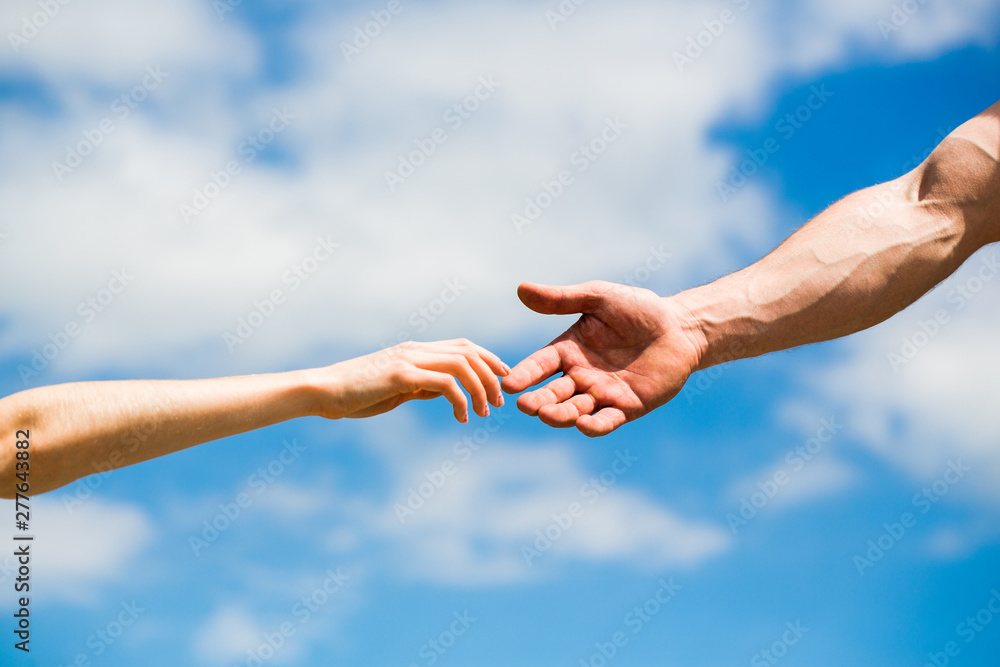 Hands of man and woman reaching to each other, support. Hands of man and woman on blue sky background. Giving a helping hand. Lending a helping hand. Solidarity, compassion, and charity, rescue
