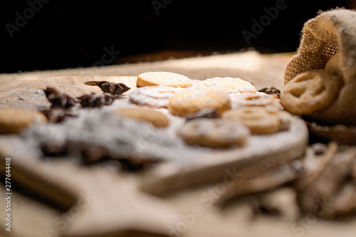 Sweet Biscuits on cutting board and canvas with powder on wooden table, vintage style. Royalty high quality free stock image.