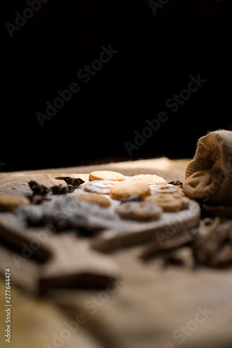 Sweet Biscuits on cutting board and canvas with powder on wooden table, vintage style. Royalty high quality free stock image.