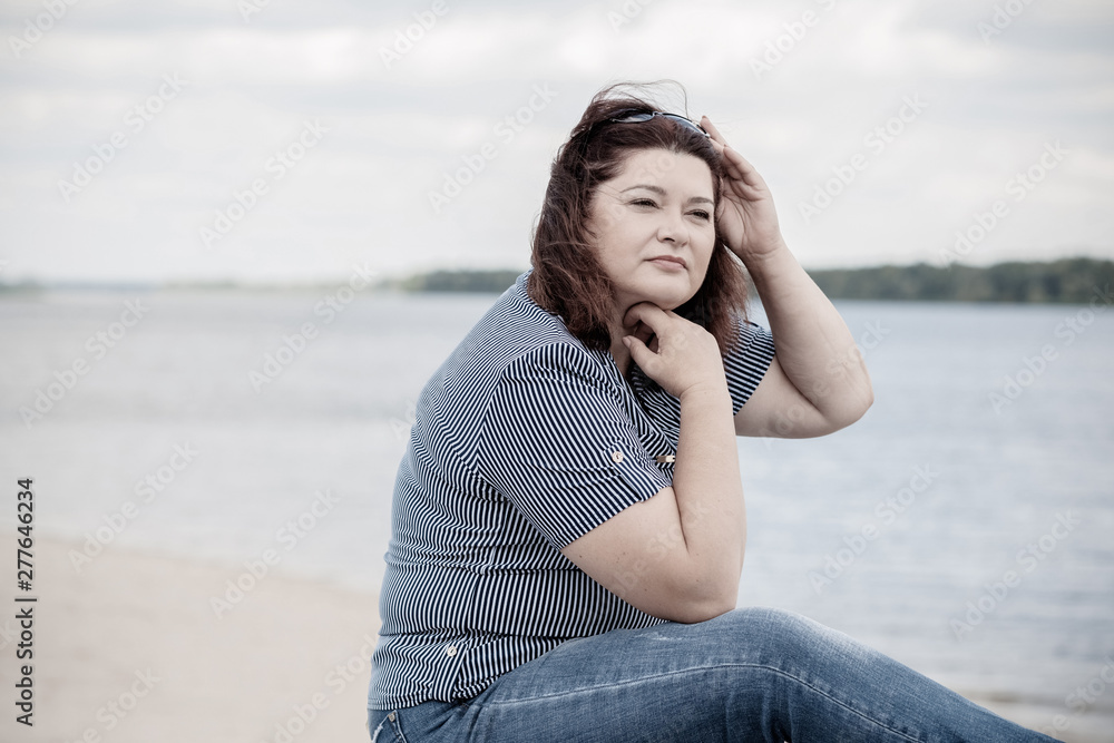 Sad Simple plump middle aged woman thinking about something, crisis of middle age and problems among overweight people 