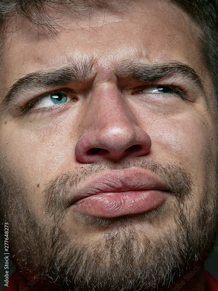 Obraz premium Close up portrait of young and emotional caucasian man. Highly detail photoshot of male model with well-kept skin and bright facial expression. Concept of human emotions. Thinking angry.