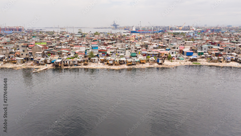 Slums in Manila near the port. Houses of poor inhabitants. A lot of garbage in the water, Philippines, top view.