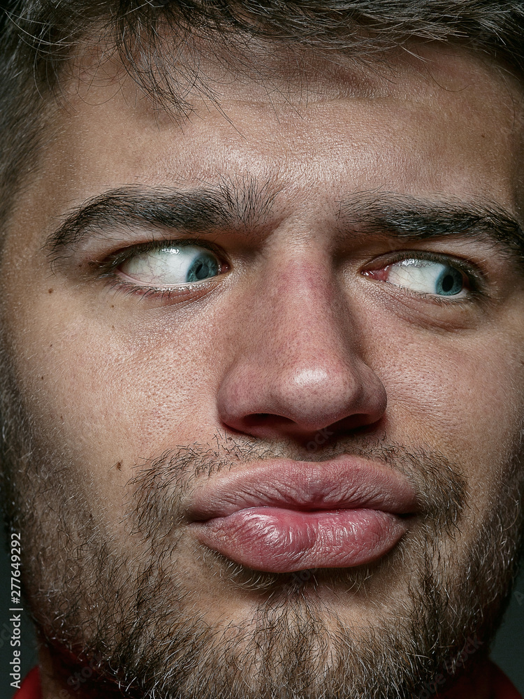 Obraz premium Close up portrait of young and emotional caucasian man. Highly detail photoshot of male model with well-kept skin and bright facial expression. Concept of human emotions. Looks playful.