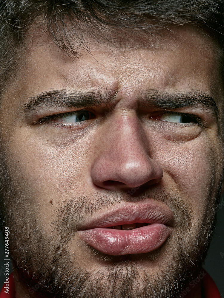 Close up portrait of young and emotional caucasian man. Highly detail photoshot of male model with well-kept skin and bright facial expression. Concept of human emotions. Disgusting feeling. Close up portrait of young and emotional caucasian man. Highly detail photoshot of male model with well-kept skin and bright facial expression. Concept of human emotions. Disgusting feeling.