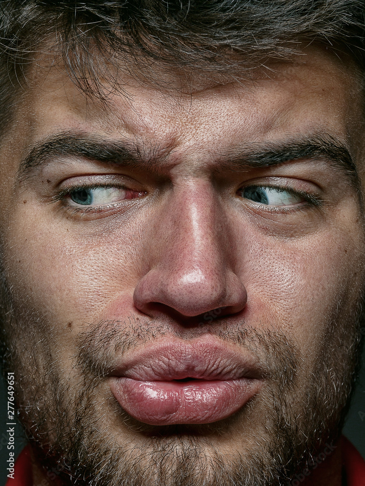 Fototapeta premium Close up portrait of young and emotional caucasian man. Highly detail photoshot of male model with well-kept skin and bright facial expression. Concept of human emotions. Disgusting feeling.