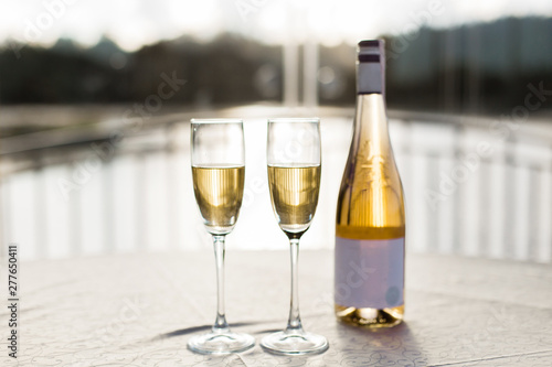Champagne for romantic celebrations and enjoy for special moments. Two romantic glasses of sparkling champagne alongside a bottle in copy space to celebrate a wedding, anniversary, New year