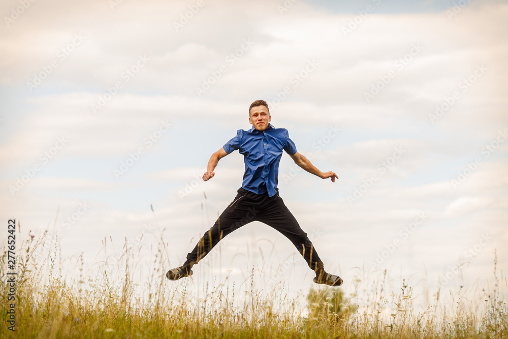 the jumping guy in the blue shirt outdoors on a summer day the jumping guy in the blue shirt outdoors on a summer day