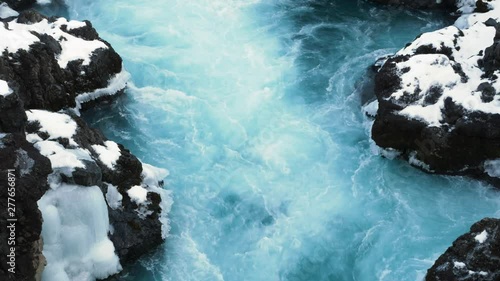 Ice blue glacial water flowing at Barnafoss waterfall in Iceland