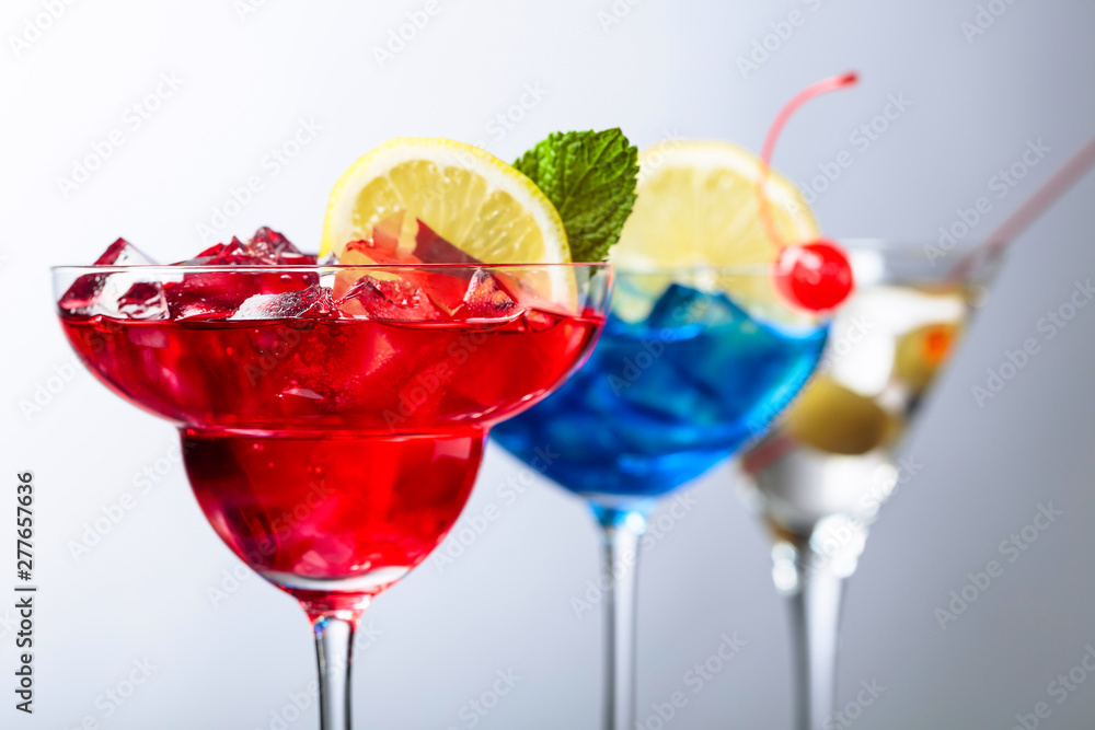 Two colorful cocktails and dry martini with green olives. Two colorful cocktails and dry martini with green olives.