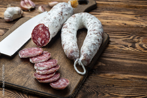 French salami on cutting board on wooden table photo