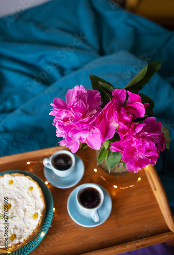 Beautiful morning Vanilla cheesecake  coffee  blue cups  pink peonies in a glass vase.