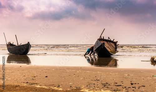 Digha, West Bengal, India. May 30,2019. Fishermen struggling to towing their fishing boat into the ocean before going for Fishing.