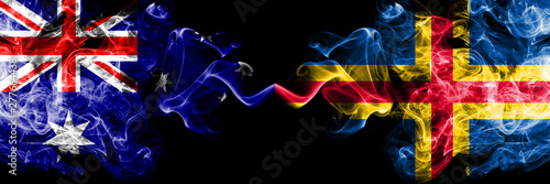 Australia vs Aland smoky mystic flags placed side by side. Thick colored silky smokes combination of national flags of Australia and Aland