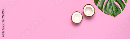Tropical leaves and fresh coconut on pink background. Flat lay, top view, copy space. Summer background, nature. Healthy cooking. Creative healthy food concept, half of coconut