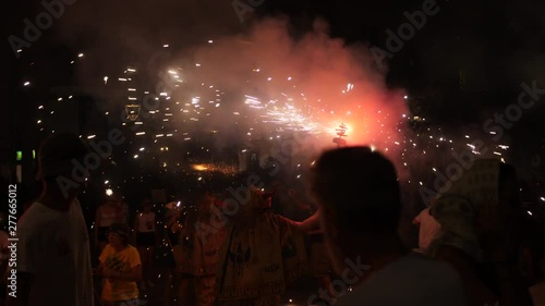 People Holding Lit Fireworks , At A Catholic Festival In Sitges, Spain. Crowds Of People Watching And Dancing, Celebrating All Over The Streets Of Sitges.  An Annual Event. Groups Dressed The Same.