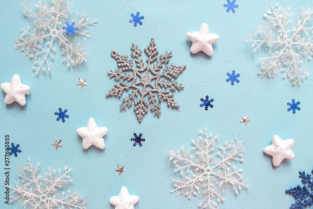 Christmas flat lay of multicolored snowflakes against blue background. Winter concept. New Year's holiday pattern Christmas flat lay of multicolored snowflakes against blue background. Winter concept. New Year's holiday pattern